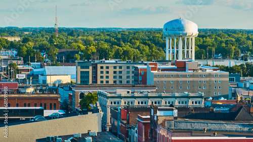 Downtown Muncie, IN aerial of city buildings leading to American Water tower and green trees