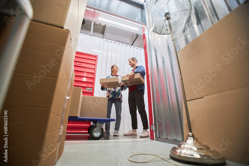 Couple renting unit at self-storage facility to store furniture when moving to another house