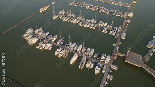 Sunrise at the marina. Boats in the estuary with the sea in the background. Aerial view from drone with many boats of different types. El Rompido. Huelva. Andalusia. Spain.