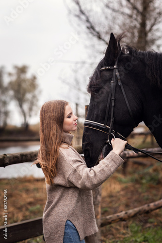 pretty young girl with long hair with a horse on an autumn day 