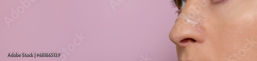 Banner Closeup Nasal Strip on Female Nose on Pink Background. Adhesive Bandage for Better Breathing. Stop Drug-Free Snoring Solution. Copy Space For Text. Horizontal Plane