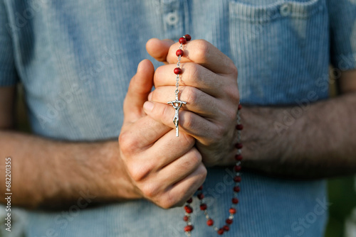 Young man praying with rosary in Eure, France.