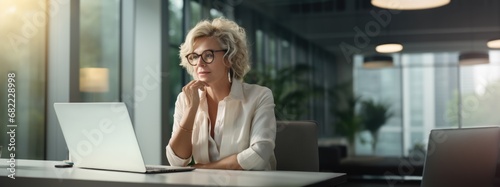 Banner mature businesswoman ceo using computer,typing, working in modern office. 50 year woman doing online business data market analysis, thinking planning tech strategy looking at laptop, copy space