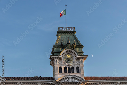 clock tower with italian flag on the town hall in Trieste, Square of Unity of Italy ( Piazza Unità d'Italia )