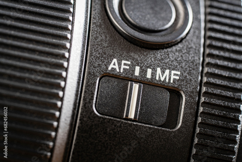 Closeup of the auto or mannual focus button on the new camera lens. Af and mf switch on the camera lens, controls of a mirrorless camera, macro