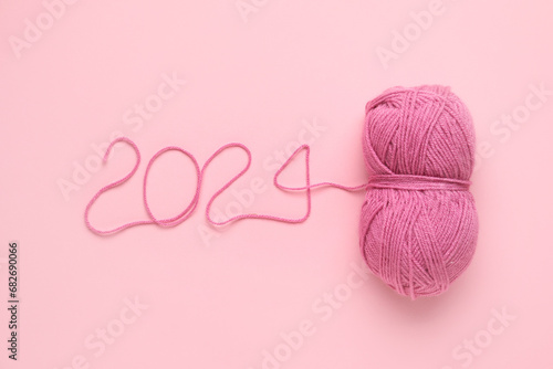 Figure 2024 made of knitting yarn on pink background