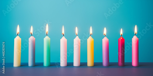13 burning colorful candles against a blue background - birthday, anniversary or celebration theme