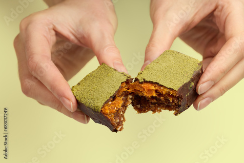 Woman's hands breaking vegan chocolate bar with dried fruits