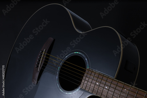Black acoustic guitar close up isolated on black background