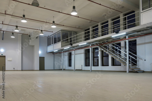 Interior of a large illuminated industrial space with mezzanine