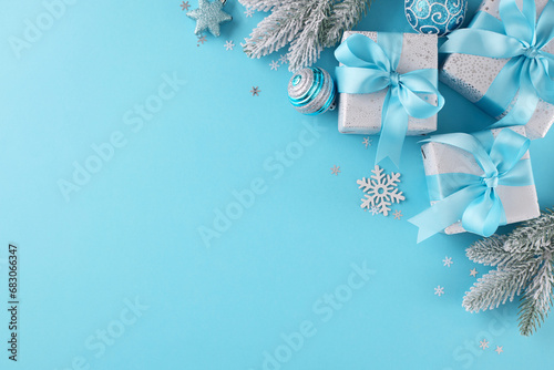 Begin your merry Christmas shopping quest. Top view photo of festive gift boxes, yule tree ornaments, frosty fir branches, snowflakes on blue background with advert space