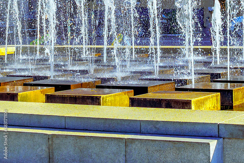 Splashes of water from a street fountain in selective focus on Lenin Square in Astrakhan in hot weather.