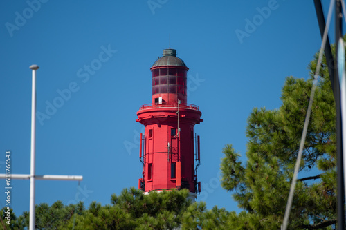 View on red lighthouse Le Phare du Cap Ferret, Arcachon Bay with many fisherman's boats and oysters farms near , Cap Ferret peninsula, France, southwest of Bordeaux, France's Atlantic coastline
