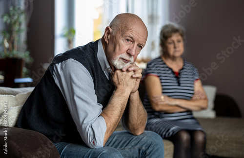 Senior couple sitting on sofa at home having a relationship problems 