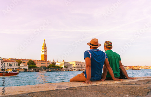 men gay couple in love travel in venice italy with amazing view of san marco tower