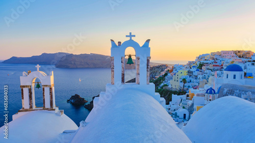 White churches an blue domes by the ocean of Oia Santorini Greece during sunset
