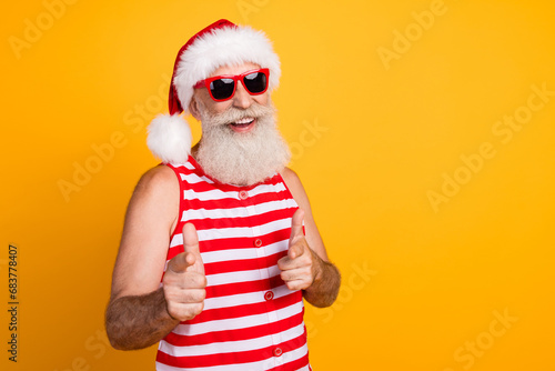 Photo of funky positive elderly guy wear new year swimsuit hat sunglass showing you empty space isolated yellow color background
