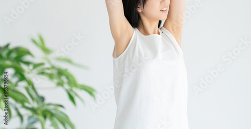 ストレッチをする白い服の若い女性