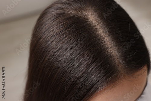 Woman with healthy hair on blurred background, closeup view