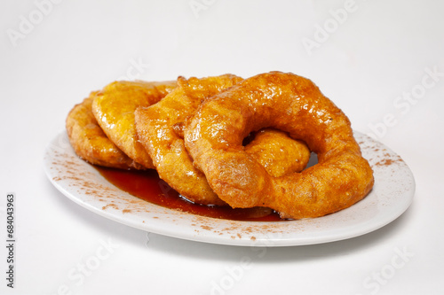 A dish of a sweet potato dessert of peruvian food, called "picarones" like a peruvian donuts