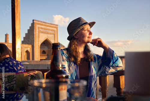 Tourist woman in ethnic dress near Madrassah in Ichan Kala of Khiva