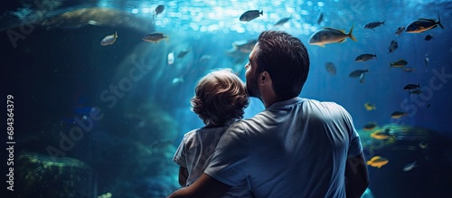 Father and son bond at the Aquarium while the son explores the underwater world on dad's back.