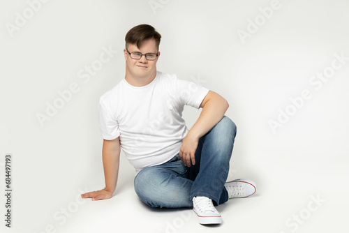 A boy with Down syndrome in glasses poses for the camera