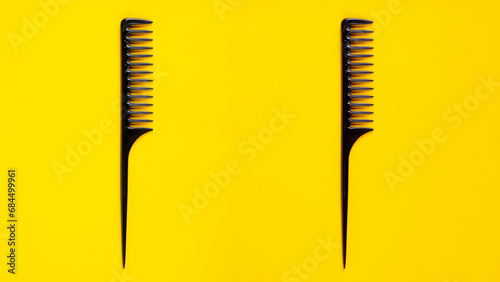 Black hair comb isolated on yellow background