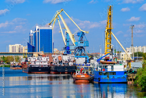 Cargo ships stand in the port of Astrakhan on the Volga River, Astrakhan cargo port. Port cranes.