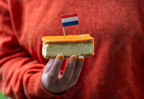 Orange Tompouce in hand, selective focus. A popular pastry eaten in The Netherlands during King's Day celebrations