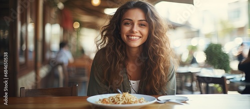 Brunette girl enjoying Italian pasta at a street cafe Advertisements design copy space image