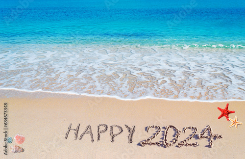 Happy 2024 written on the sand