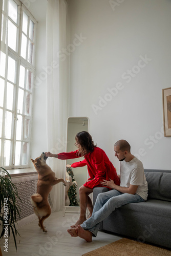 Happy beautiful couple with shiba inu dog at home