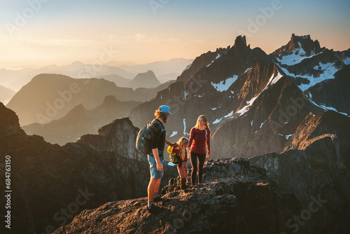 Family hiking together travel in Norway mountains: parents and child outdoor climbing adventure healthy lifestyle outdoor active vacations mother and father with kid trekking