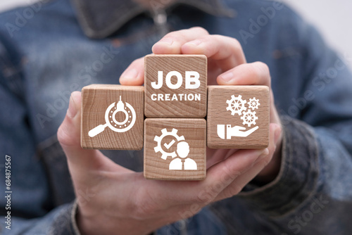 Man holding wooden cubes with icons sees inscription: JOB CREATION. Job creation and stability business concept. Employment.