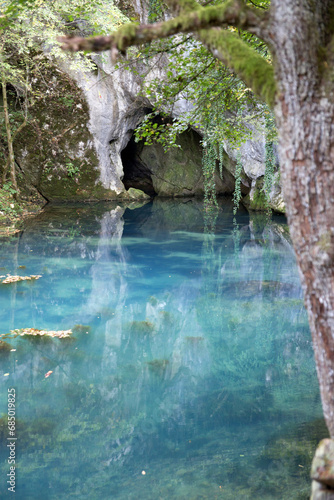 Beautiful turquoise blue water of river Krupaja surrounded with forest and cave.