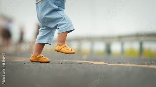 close up leg of infant baby learning to walking first step on pathway