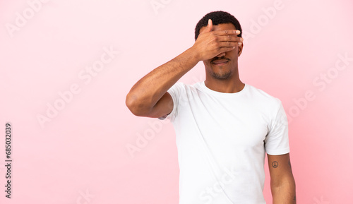 African American man on copyspace pink background covering eyes by hands. Do not want to see something