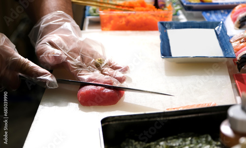 Chef use sharp knife slicing Tuna red fish for sashimi. Enjoy Omakase experience at Japanese Sushi Restaurant.