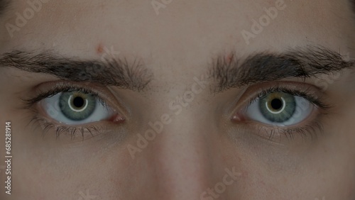 Eyes of a young man macro shot. Enlarged pupils, due to prolonged use of gadgets. Dry eye syndrome. Health concept.