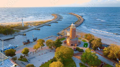 Port and lighthouse in Kołobrzeg, Poland. Photo taken with a drone at the beginning of autumn. The rippling, blue Baltic Sea.