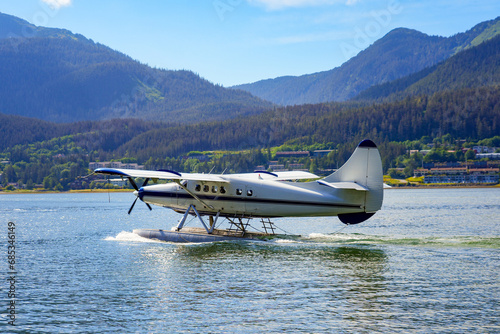 Seaplane landing in the waters of the Gastineau Channel in Juneau, the capital city of Alaska, USA - Wings Airways scenic flight taking tourists to the Taku Glacier Lodge