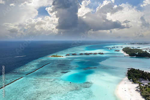 Top view of Maldives (Maldive) island, with white sandy tropical exotic beach and turquoise colored sea with palm trees. Drone shooting