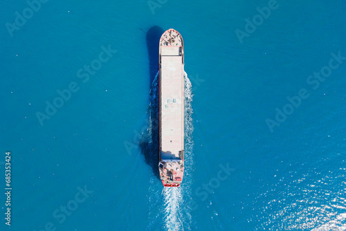 General cargo ship or bulk carrier vessel cruising in sea. top down view