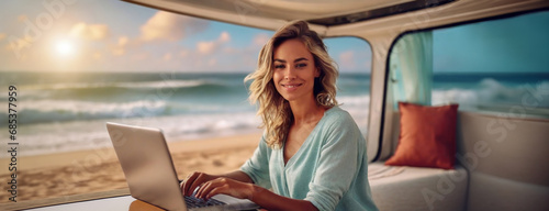 Living and working inside camper van vehicle in travel and digital nomad free lifestyle. Smiling woman sitting in a motorhome and enjoy relax with laptop. Beach background outside the window.