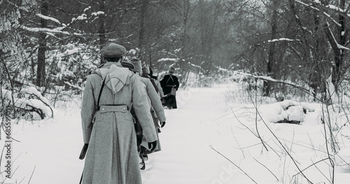 Army on Marching. Men Dressed As White Guard Soldiers Of Imperial Russian Army In Russian Civil War s Marching Through Snowy Winter Forest. Historical Reenactment of Civil War. Black And White .