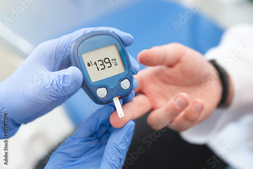 Doctor using glucometer, blood glucose test