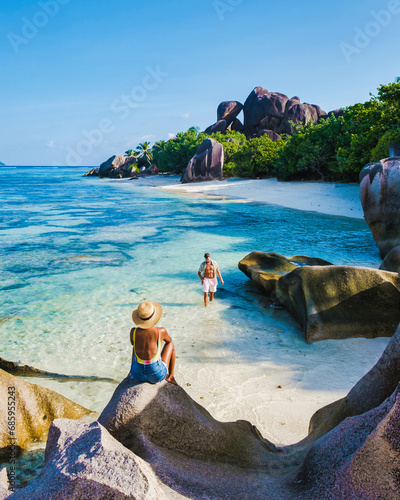 Anse Source d'Argent beach, La Digue Island, Seychelles, couple men and woman walking at the beach during sunset at a luxury vacation in the Seychelles La Digue Island