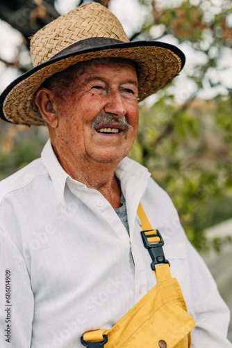 Portrait of an old farmer with a leghorn looking away.