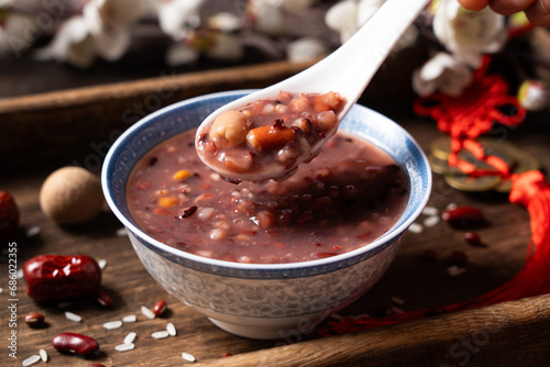  red rice porridge in a bowl. traditional food Laba porridge on table.